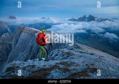 Europe, Italie, Alto Adige - Südtirol, Hiker au crépuscule sur le sommet du Picco di Vallandro / Dürrenstein regardant le Tre Cime di Lavaredo et Cristallo montagne, Dolomites Banque D'Images