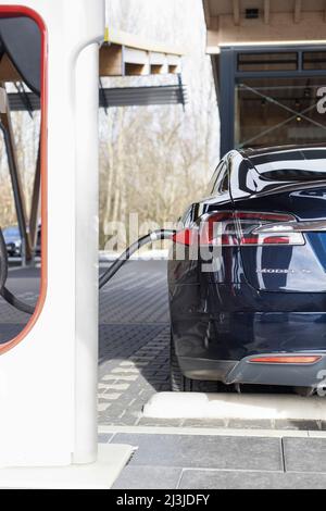 Tesla au point de charge d'une station de Supercharger en Allemagne Banque D'Images