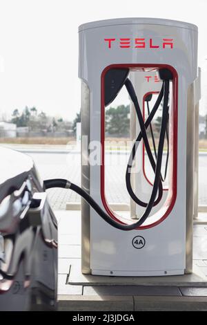 Colonne de charge Tesla avec voiture connectée à une station de charge en Allemagne Banque D'Images