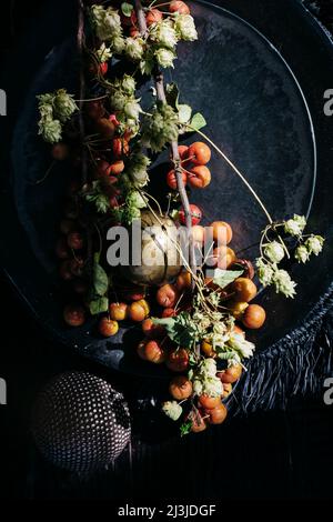 Branche décorative de pomme de cerise dans un bol noir Banque D'Images