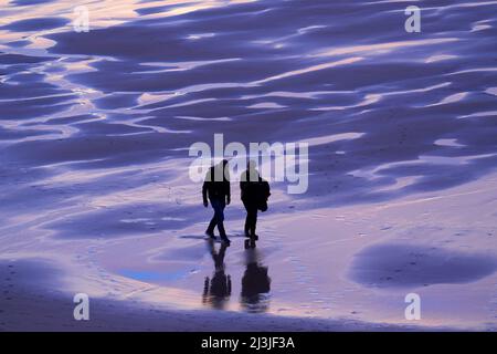 Couple de personnes âgées sur la plage, ambiance nocturne, eau marémotrice, Playa de Canallave, Liencres Cantabria, Espagne Banque D'Images