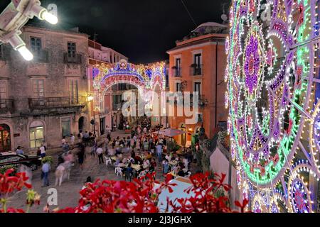 NOVARA DI SICILIA, ITALIE - 14 AOÛT 2019 : les gens ont bondi sur une petite place décorée de lumières festives pour la fête de l'Assomption de la Vierge Banque D'Images