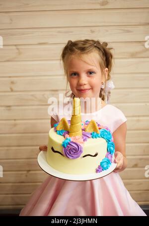 Fille tenant un gâteau sous la forme d'un Unicorn Banque D'Images