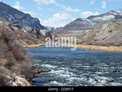 Shoshone River en direction du parc national de Yellowstone depuis Cody, Wyoming. Au printemps, la ruée de l'eau est due à la fonte de la neige dans les montagnes. Pêcheur aussi. Banque D'Images