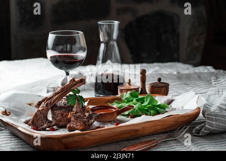 Filet d'agneau grillé sur une assiette de bois avec vin Banque D'Images