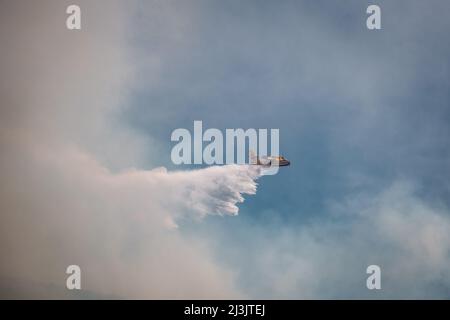 Speloncato, Corse, France - 8th avril 2022. Un avion-feu de Canadair de la Civile française de la Securitite fait couler de l'eau au-dessus d'un feu de forêt au-dessus du village de SPE Banque D'Images