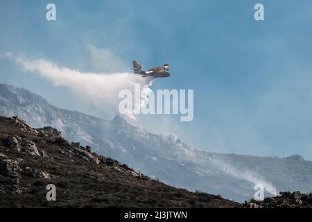 Speloncato, Corse, France - 8th avril 2022. Un avion-feu de Canadair de la Civile française de la Securitite fait couler de l'eau au-dessus d'un feu de forêt au-dessus du village de SPE Banque D'Images