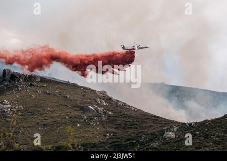 Speloncato, Corse, France - 8th avril 2022. Un avion de feu Dash 8-400 de la Civile française fait feu sur un feu de forêt au-dessus du vi Banque D'Images