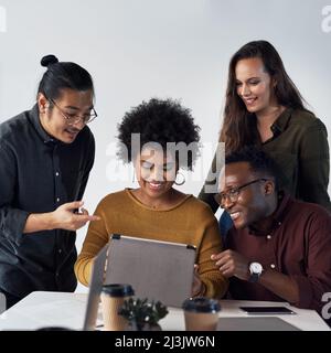 Vivre dans une génération millénaire d'entrepreneurs. Photo rognée d'un groupe diversifié de professionnels travaillant ensemble sur une tablette au bureau. Banque D'Images