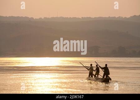 De jeunes pêcheurs congolais pagayez sur leur pirogue à travers le fleuve Congo.; Congo River, République démocratique du Congo. Banque D'Images