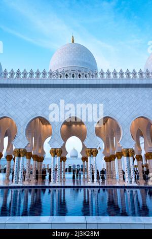 Une vue sur l'un des bassins réfléchissants dans la cour de la Grande Mosquée d'Abu Dhabi, eau tandis que la journée s'estompe dans la nuit. Banque D'Images