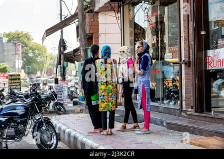 Groupe de jeunes femmes debout ensemble sur un trottoir le long d'une rue dans une ville en Inde; Amritsar, Punjab, Inde Banque D'Images