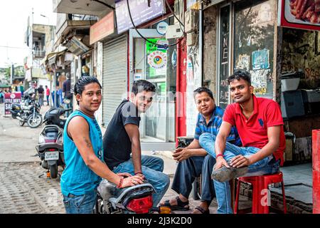 Jeunes hommes assis ensemble dans une rue d'une ville en Inde; Amritsar, Punjab, Inde Banque D'Images