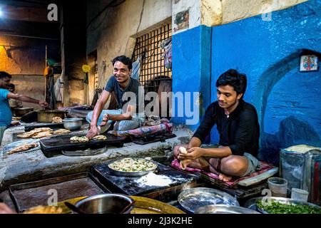 Jeunes hommes travaillant dans une cuisine commerciale préparant des aliments sous la lumière en Inde; Amritsar, Punjab, Inde Banque D'Images