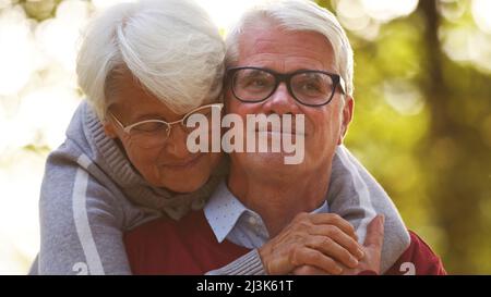 Portrait de la bonne senior caucasien couple marié femme regardant vers le bas, homme regardant loin les deux sourire parc arrière-plan sélectif foyer . Photo de haute qualité Banque D'Images