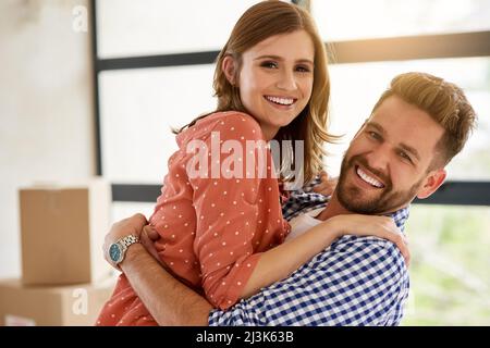 Nous ne pourrions pas être plus heureux de commencer une nouvelle vie ensemble. Portrait d'un jeune couple célébrant son déménagement dans une nouvelle maison. Banque D'Images