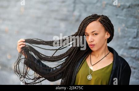 Braïdes magnifiquement torsadés. Portrait d'une jeune femme attrayante avec de belles tresses posant à l'extérieur. Banque D'Images