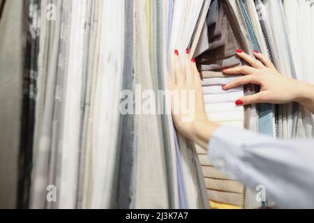 Femme choisit le tissu de la nouvelle collection dans le salon Banque D'Images