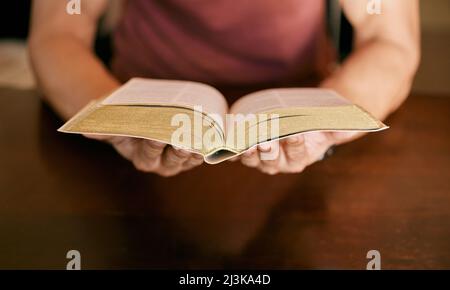 Ma bible est l'un de mes effets les plus importants. Photo d'un jeune homme assis tenant une bible dans ses mains. Banque D'Images