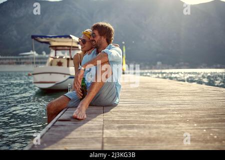 Couple romantique souriant contemplant la vue sur la montagne, appréciant dans la nature et buvant de la bière Banque D'Images