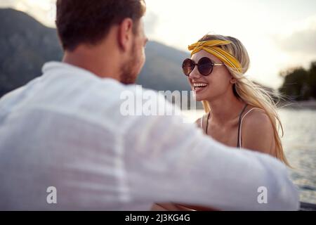 Vacances romantiques.fille souriante assise sur la rive du lac et appréciant Banque D'Images