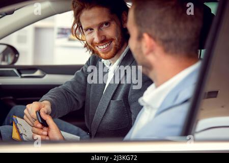 Homme prenant la clé d'une nouvelle voiture dans une voiture Banque D'Images