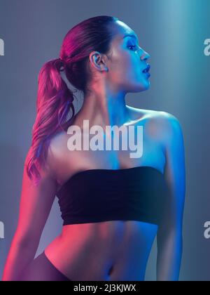 Absolument magnifique. Photo en studio d'une belle jeune femme posant sur un fond multicolore. Banque D'Images