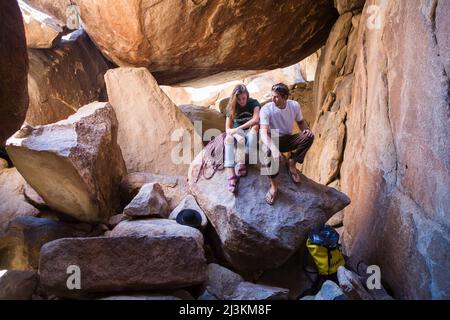 Les grimpeurs se reposer sur les rochers de granit dans la région de Joshua Tree National Park. Banque D'Images