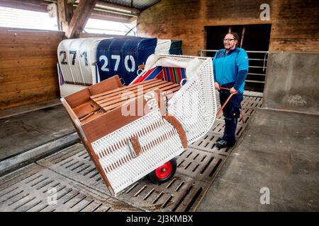 Hooksiel, Allemagne. 05th avril 2022. Maik Haag, employé de Wangerland Touristik GmbH, conduit une chaise de plage hors du stockage d'hiver avec un chariot. Les préparatifs pour le début de la saison sont en cours sur la côte de la mer du Nord de Basse-Saxe. Credit: Hauke-Christian Dittrich/dpa/Alay Live News Banque D'Images