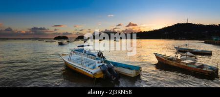 Bateaux amarrés dans le port de la baie de Samana le long de la rive de Samana au coucher du soleil; péninsule de Samana, République dominicaine, Caraïbes Banque D'Images