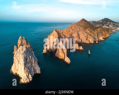 Des formations rocheuses spectaculaires sur la pointe sud de la péninsule de Baja appelée terres se terminent de l'air au coucher du soleil avec la ville de la station balnéaire de Cabo San Lucas i.. Banque D'Images