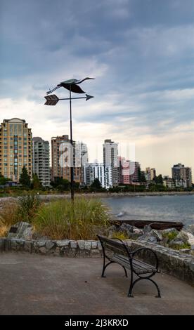 Point de vue avec banc et girouette, et bâtiments résidentiels hauts en couleur le long d'un secteur riverain de la plage Ambleside à West Vancouver, ... Banque D'Images