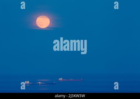 Pleine lune se levant sur les navires ancrés dans la baie de Lyme, au large de Shaldon, Devon, Grande-Bretagne; Shaldon, Devon, Angleterre Banque D'Images