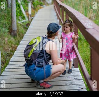 Mère et jeune fille tiennent la main et marchent sur un sentier lors d'une randonnée ensemble dans le parc provincial marin de Smuggler Cove le long de la Sunshine Coast of B.. Banque D'Images