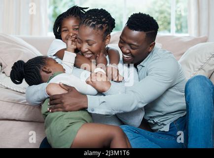 La famille se sent comme un câlin chaud et réconfortant. Photo d'une famille heureuse se détendant ensemble à la maison. Banque D'Images