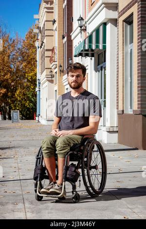 Portrait extérieur d'un jeune paraplégique dans son fauteuil roulant sur un passage de la ville lors d'une belle journée d'automne; Edmonton, Alberta, Canada Banque D'Images