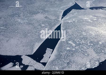 Un grand morceau de glace de mer détaché se brise loin de la structure principale. Photographié de la fenêtre de l'avion Twin Otter en route jusqu'à ... Banque D'Images