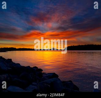 Couleurs éclatantes d'un lever de soleil vu depuis le sentier côtier de Vancouver Ouest, avec vue sur le pont Lions Gate au loin Banque D'Images