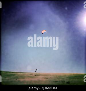 Un garçon de 12 ans prend le vol tout en faisant du sable sur la grande dune du parc national de Jockey Ridge.; Nags Head, Outer Banks, Caroline du Nord. Banque D'Images