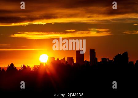 Ciel spectaculaire et coloré avec un paysage urbain et une rafale de soleil silhouettés; Calgary, Alberta, Canada Banque D'Images