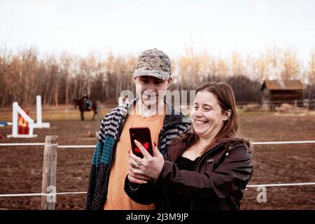 Une mère épileptique qui se fait autoportrait avec son fils qui souffre du syndrome d'Aspberger dans un centre équin; Westlock, Alberta, Canada Banque D'Images