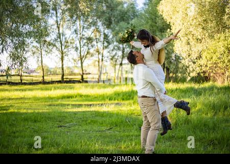 Mariage. Une paire d'amoureux dans une forêt de pins. La mariée et le marié dansent, l'homme a pris la femme. Il la pointe. Banque D'Images