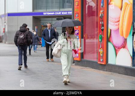 Le temps semble relativement sec ce matin à Londres, avec des trajets occasionnels tandis que les navetteurs passent par Tottenham court Road et Oxford Circ Banque D'Images