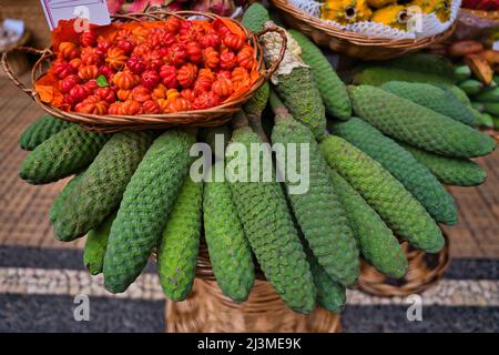 Monstera fruit ou bananes, Monstera deliciosa, avec un besaket pitangas sur un marché à Funchal, dans les îles de Madère, au Portugal Banque D'Images