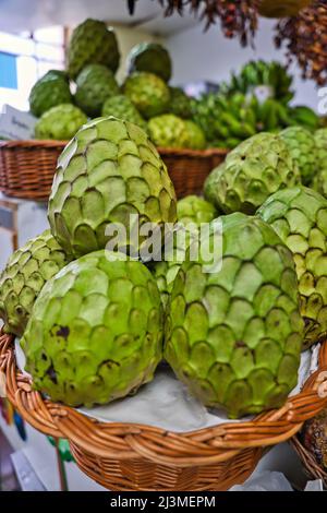 Photo macro des fruits de Cherimoya dans un panier en osier. Le cherimoya est nommé scientifiquement Annona cherimola sur le marché de Funchal, Madère, Portugal Banque D'Images