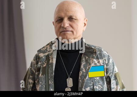 L'homme ukrainien guerrier vêtu d'un uniforme militaire de pixel le drapeau jaune-bleu de l'Ukraine Banque D'Images