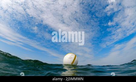 Bouée dans la mer avec ciel bleu et nuages intéressants Banque D'Images