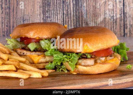 hamburger de poulet avec frites sur une planche de bois Banque D'Images