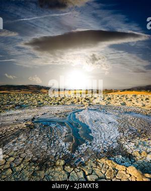 paysage surréaliste volcan qui éclate de boue liquide au coucher du soleil Banque D'Images