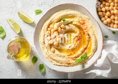 Le houmous végétalien et traditionnel comme en-cas sain et végétalien. Houmous servis huile d'olive et feuilles de menthe servies. Banque D'Images